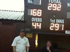 Justin Rose and Simon Rippingale pictured in front of Worlington's scoreboard after Rose's match-winning 168 not out.